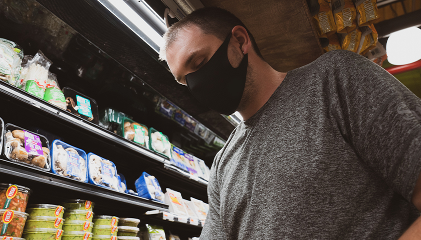Man at grocery store wearing a black mask